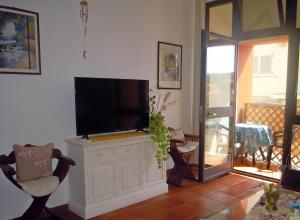 a living room with a flat screen tv on a white cabinet at Maisonette Asfodelo in Palau