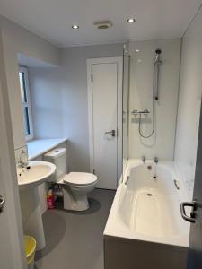 a bathroom with a tub and a toilet and a sink at St Andrew's Lettings in Peterhead +17 photos