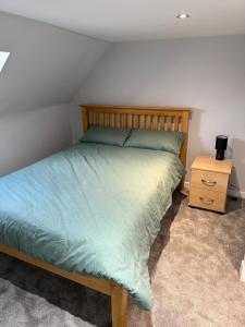 a bed with a wooden headboard and a night stand at St Andrew's Lettings in Peterhead
