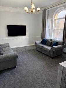 a living room with two couches and a flat screen tv at St Andrew's Lettings in Peterhead