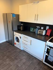 a kitchen with a refrigerator and a washing machine at St Andrew's Lettings in Peterhead