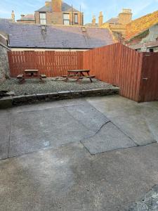 two picnic tables in front of a fence at St Andrew's Lettings in Peterhead