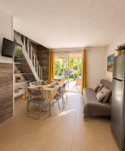 a kitchen and living room with a table and a couch at Le Maquis Plage Corse in Poggio-Mezzana