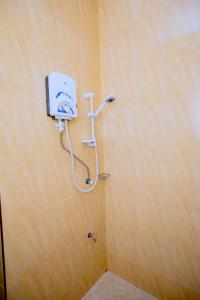 a bathroom with a shower with a soap dispenser on the wall at Clisa Rest House in Karatu +23 photos