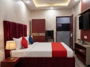 a bedroom with a large bed with red and blue pillows at Cloud Cobe in New Delhi