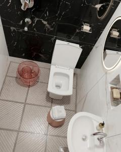 a black and white bathroom with a toilet and a sink at Cloud Cobe in New Delhi