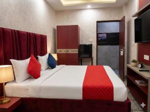a bedroom with a large bed with red and blue pillows at Cloud Cobe in New Delhi