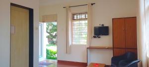 a living room with a tv and a window at SUSAGADE in Vagator +15 photos