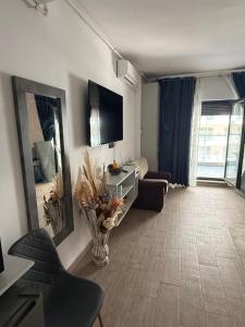 a living room with a couch and a mirror at Studio Matias 2 Casa Del Mar in Mamaia