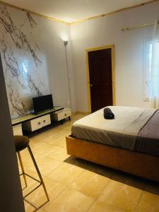 a bedroom with a bed and a desk with a laptop at Amalis in Moroni