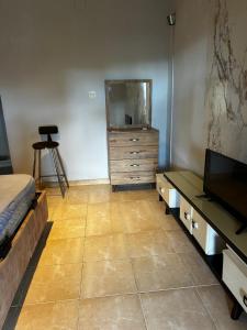 a bedroom with a bed and a dresser and a television at Amalis in Moroni