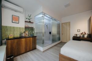 a bathroom with a shower and a bed in a room at Anchie Hanoi House in Hanoi