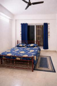 a bedroom with a bed and a ceiling fan at The Travellers Nest in Siliguri