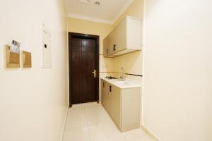 a small kitchen with a sink and a door at فندق النخبة الماسي - Diamond Elite Hotel in Medina