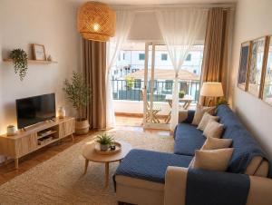 a living room with a blue couch and a tv at SandyBeachApartment in Porto Santo