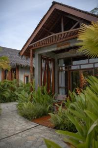 a resort building with a patio and plants at The Salty Jungle in Cijulang Nusawiru Airport