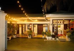 a house with lights and potted plants in front of it at Diva Villa Airport Transit Hotel in Katunayaka