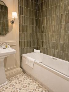 a bathroom with a bath tub and a sink at Donegal Manor in Donegal