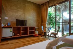 a hotel room with a tv and a bed at Blue River Resort in Phitsanulok