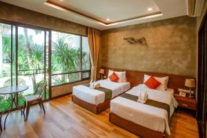 a bedroom with two beds and a large window at Blue River Resort in Phitsanulok +92 photos