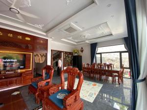 a living room with chairs and a television and a table at Thành Đạt Homestay Cát Bà in Cat Ba