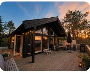a large wooden deck with a house with a roof at Modern chalet in Malangen in Mestervik