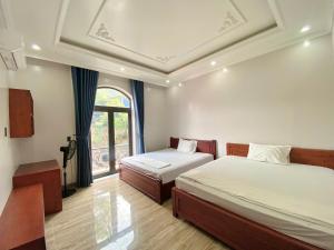 a bedroom with two beds and a window at Thành Đạt Homestay Cát Bà in Cat Ba