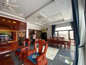 a living room with chairs and a television and a table at Thành Đạt Homestay Cát Bà in Cat Ba