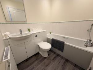 a white bathroom with a toilet and a sink at Inverness Retreat in Inverness +8 photos