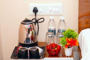 a coffee maker on a table with strawberries and water bottles at The Serenity Resort Panchgani in Panchgani