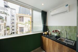 a kitchen with a sink and a large window at Anchie Hanoi House in Hanoi +83 photos