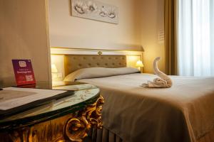 a hotel room with two beds and a glass table at Hotel Genova Liberty in Genoa +128 photos