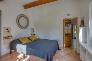 a bedroom with a bed and a mirror on the wall at L'Instant Cabanon, 349 chemin des Maridats in Bédoin +30 photos