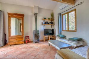 a living room with a wood stove and a tv at L'Instant Cabanon, 349 chemin des Maridats in Bédoin