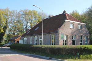 a brick house with a street light in front of it at Karin's kruidenhoeve B&B kamer Kamille met Finse sauna in Lutten