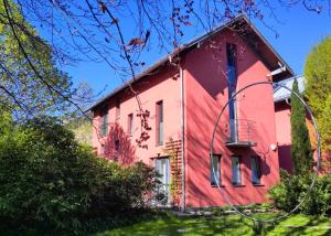 a red house with a balcony on the side of it at Zimmer am Ring - ruhiges Zimmer im Grünen, Frühstück auf eigener Terrasse mit Morgensonne und fußläufig zum Badeplatz Schwarzindien am Mondsee in Sankt Lorenz