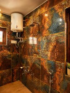 a bathroom with a shower with a stone wall at SH Valley Homestay in Srinagar
