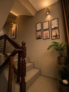 a hallway with a staircase with pictures on the wall at SH Valley Homestay in Srinagar +1 photo