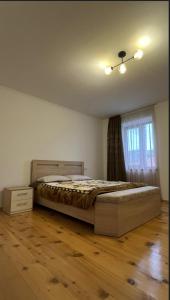 a bedroom with a bed and a dresser and a window at Nia's Guesthouse in Zemo Alvani