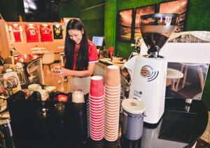 a woman standing behind a counter with a blender at Destination Boutique Hotel in Pattaya