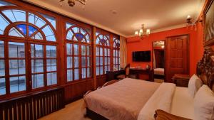 a bedroom with orange walls and windows and a bed at Grand Hotel 1902 in Baku