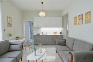a living room with two couches and a kitchen at Aphrodite Old Town Suite Xanthi in Xanthi