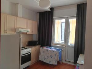 a small kitchen with a stove and a window at Абай2 169 in Astana