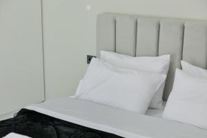 a white bed with white pillows on it at Aphrodite Old Town Suite Xanthi in Xanthi