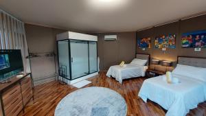 a hotel room with two beds and a television at The Halfway Cafe-Dauin, Glamp1 - Cricket in Dauin +19 photos