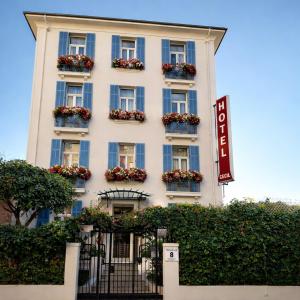 a tall white building with flower boxes on it at Hôtel de charme CECIL in Juan-les-Pins +19 photos