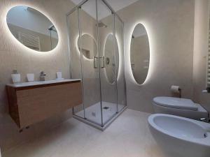 a bathroom with a sink and a toilet and mirrors at Casa Acqua e Sale - 50 mt dal mare in Fano +18 photos