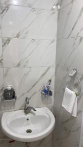 a bathroom with a sink and a white marble wall at Airport sky in Amman +20 photos