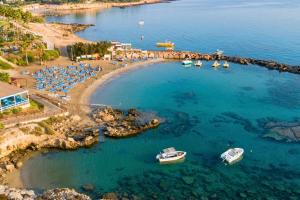 an aerial view of a beach with boats in the water at Cavo Maris Beach Hotel & Suites in Protaras