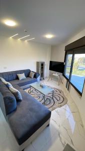 a living room with a blue couch and a table at Airport sky in Amman